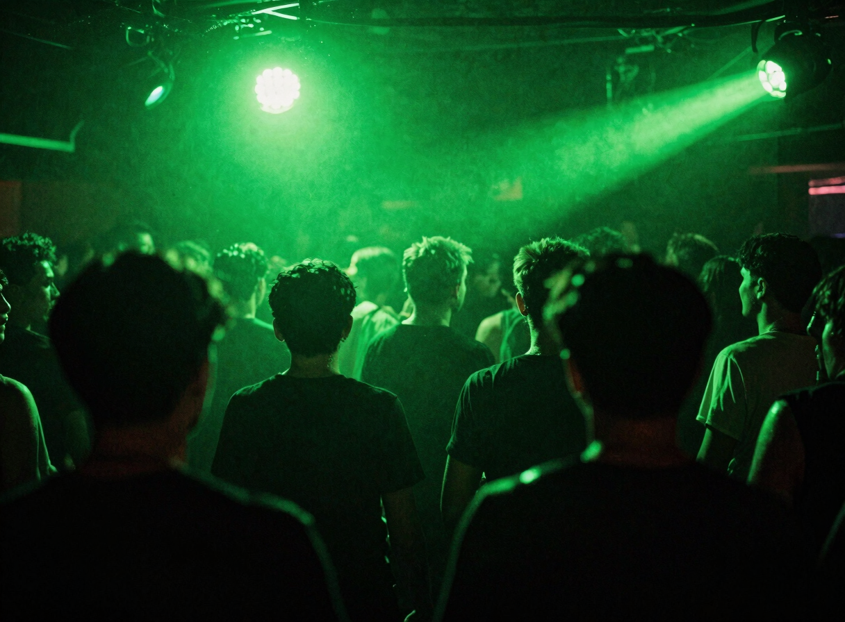 Archive Low-angle wide shot of a sweat-drenched crowd in motion under high-contrast acid green strobe lights, deep shadows, heavy film grain, raw underground club energy.